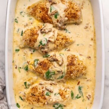 overhead view of a large pan filled with baked tuscan chicken breasts.